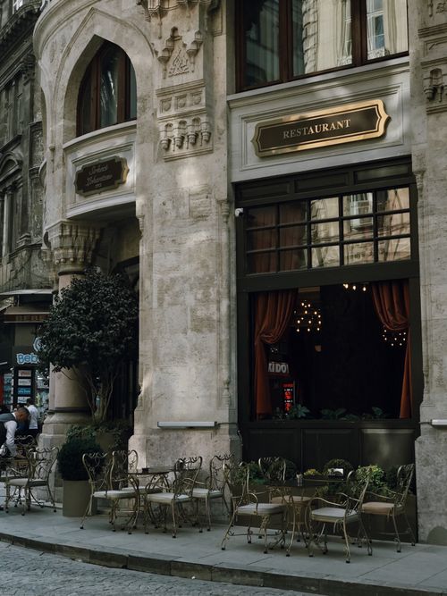 Free Elegant restaurant facade with outdoor seating on a European city street. Stock Photo