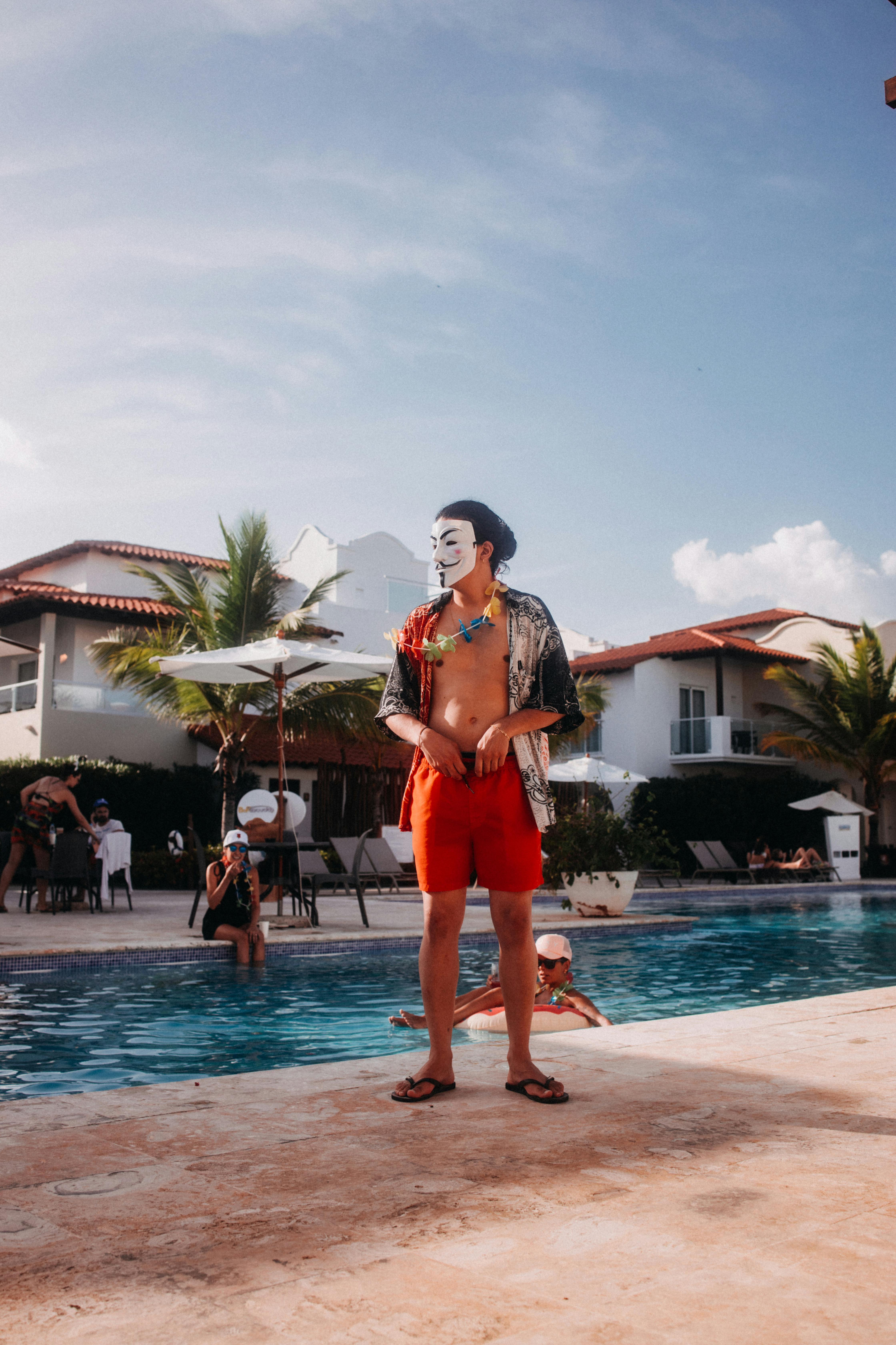 a man wearing a mask while standing on the pool side