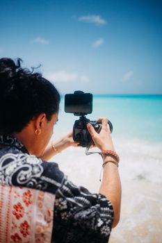 Photographer capturing scenic ocean view on a sunny day, perfect for travel inspiration.
