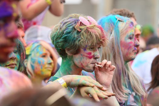 A lively outdoor Holi festival scene with participants covered in vibrant powders, celebrating joyfully.