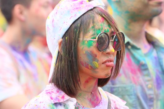Colorful Holi festival celebration in New York with joyful participants.