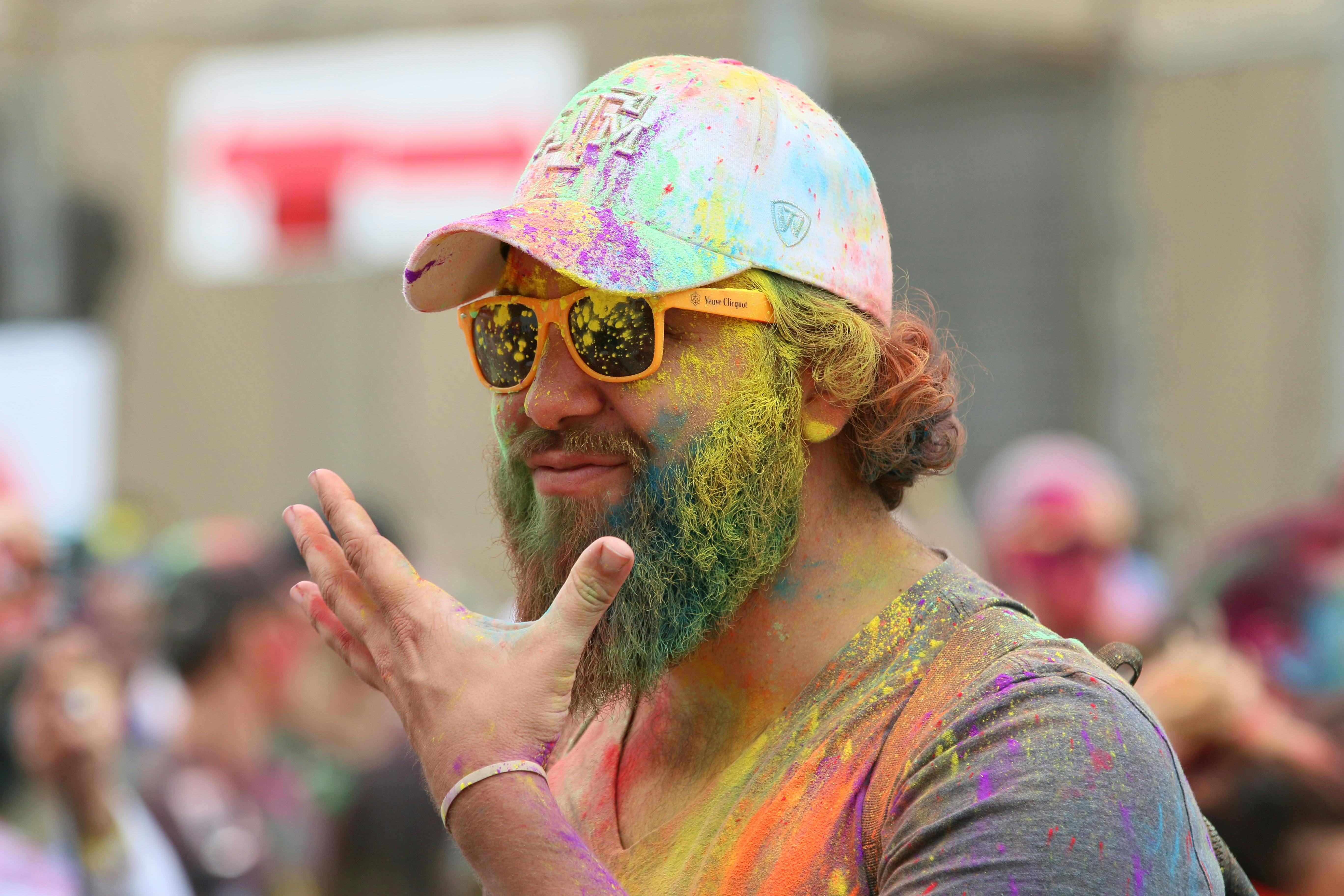 man in orange and yellow floral shirt wearing yellow sunglasses