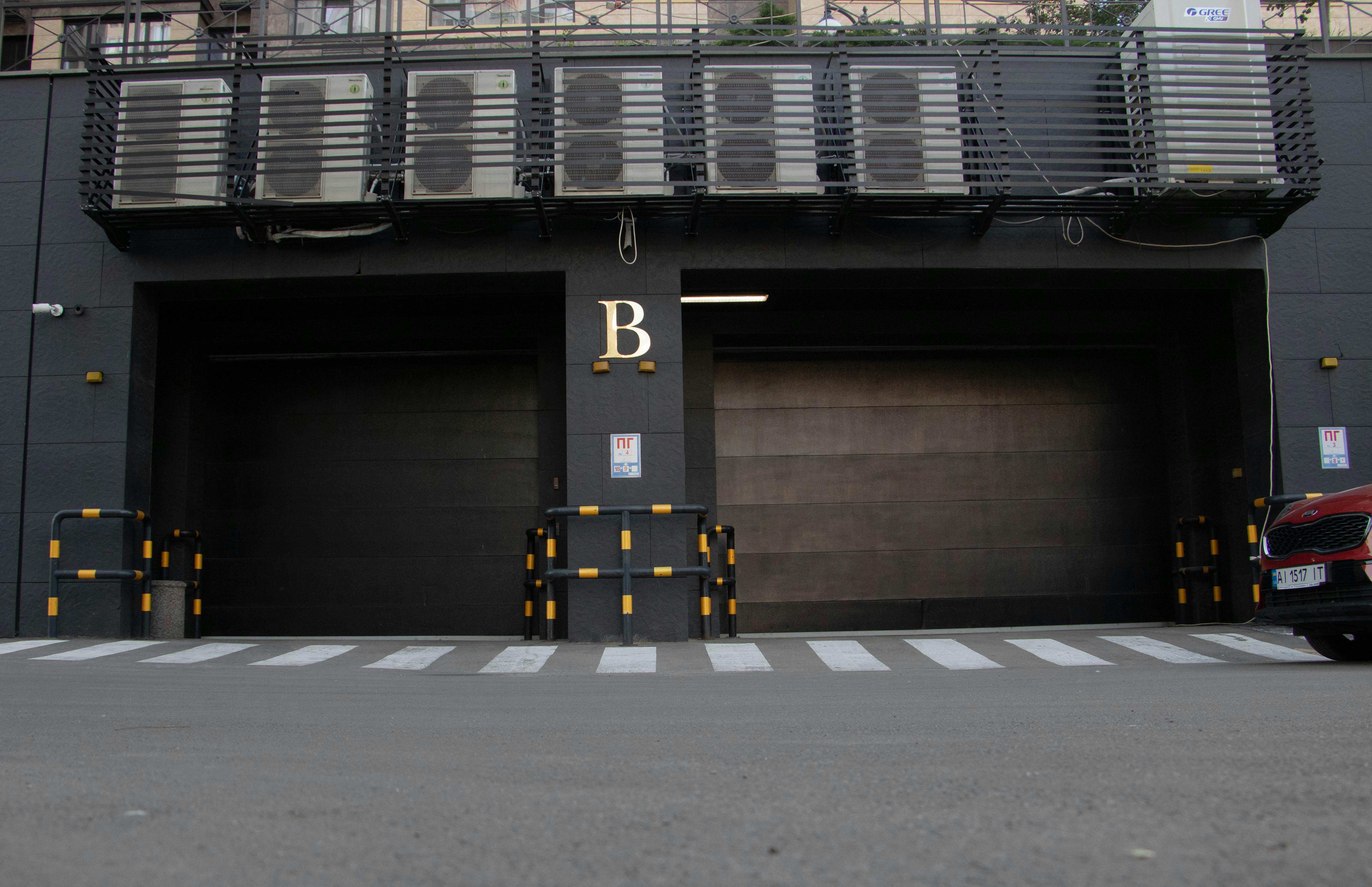Modern garage entrance with air conditioning units above and a zebra crossing in Kyiv, Ukraine.