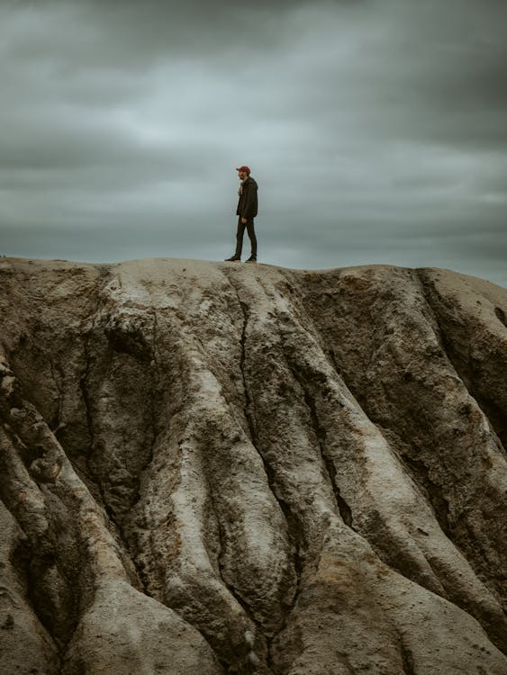 Photo of a Man Standing on a Rock · Free Stock Photo