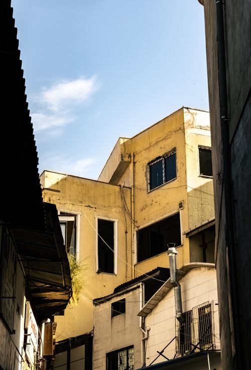 Free Angles of yellow urban buildings under a clear blue sky, capturing a unique city perspective. Stock Photo