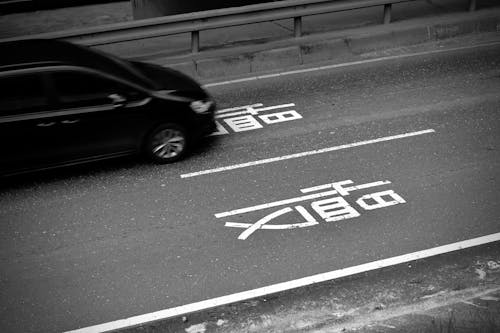 Free Grayscale Photo of Black Car on Road Stock Photo