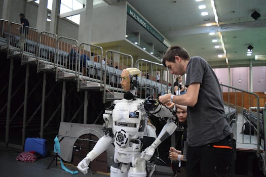 Technician working on humanoid robot at a tech exhibition in Guimaraes, Portugal.