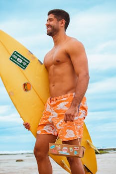 Smiling man enjoying a day at the beach with a surfboard, embodying leisure and summer vibes.