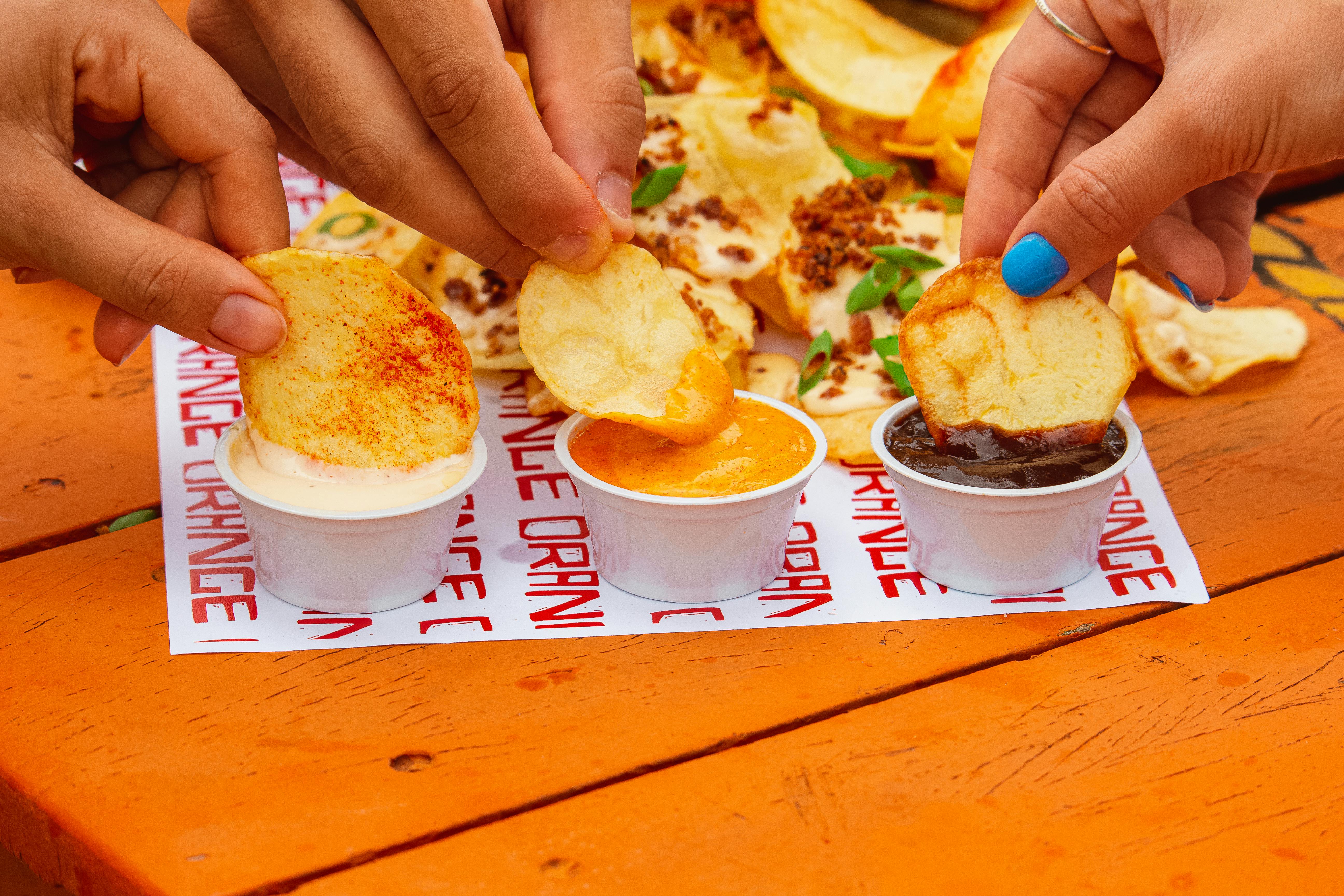 Hands Dipping Chips in Sauce · Free Stock Photo