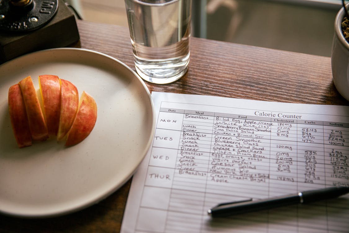 Free Apple Slices Beside a Calorie Counting Form Stock Photo