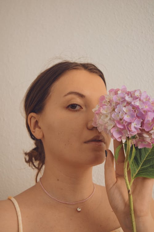 Woman Holding a Pink and White Flower