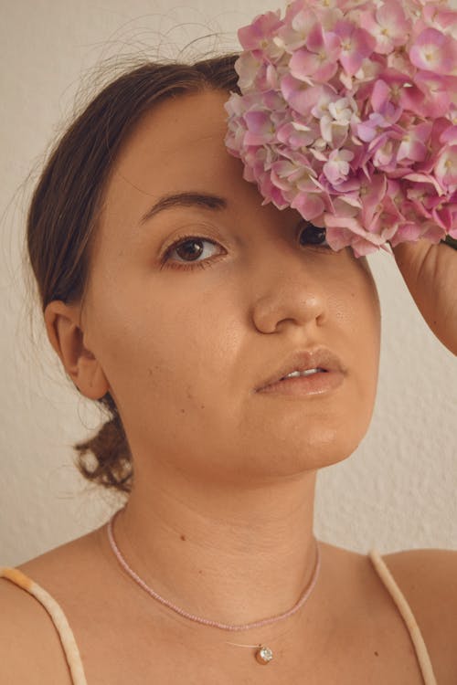 Woman Holding Pink Flowers Near Her Face