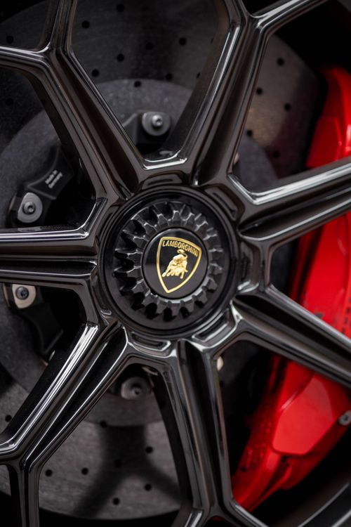 Free Detailed close-up of Lamborghini wheel showcasing the black alloy rim and red brake caliper. Stock Photo