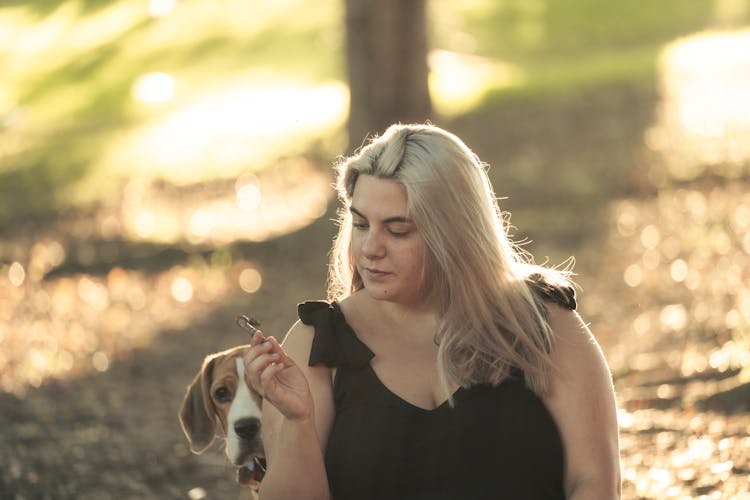 A Dog Standing Beside A Woman In Black Top