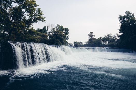 A tranquil waterfall flowing through a verdant forest, creating a serene and calming scene.