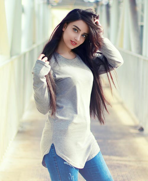 Free Woman in Gray Long Sleeve Shirt and Blue Denim Jeans Stock Photo