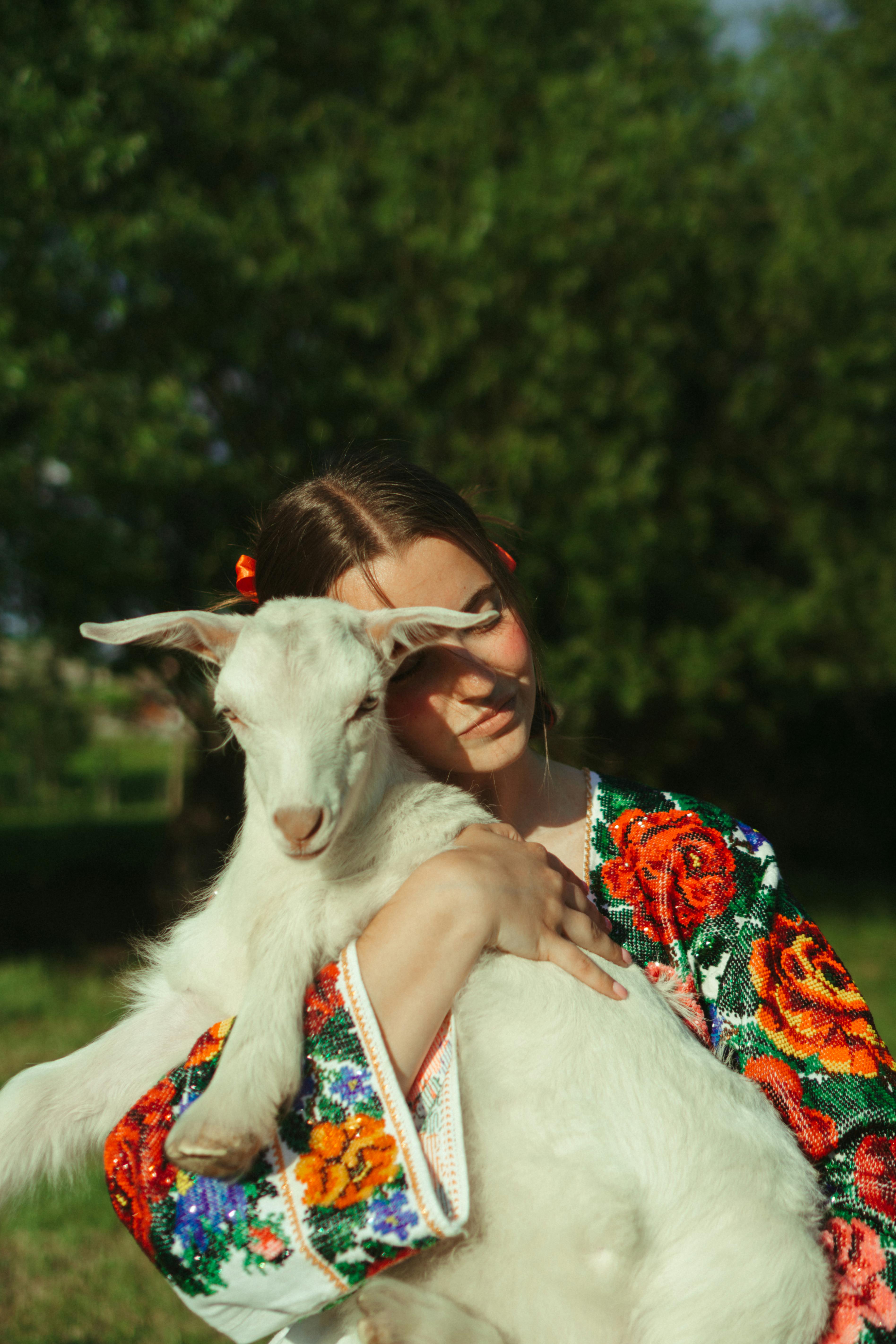 Woman in Floral Dress Holding a Goat · Free Stock Photo