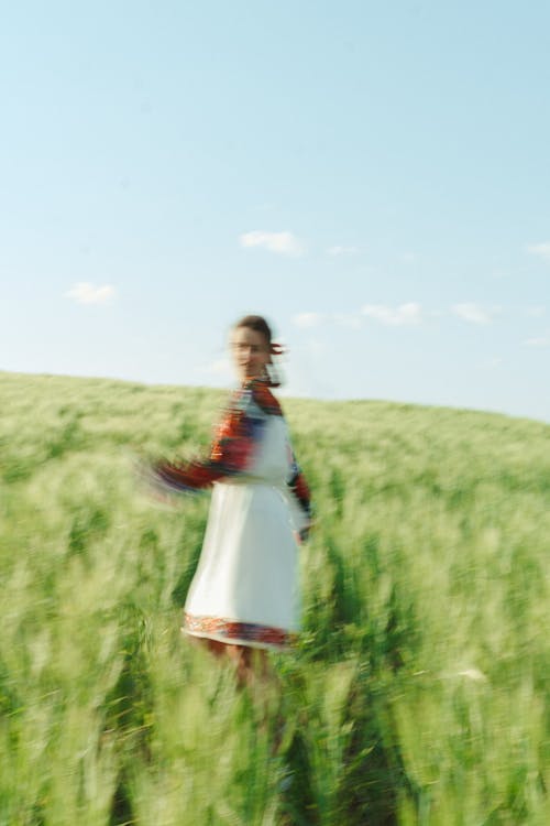 Blurry Photo of a Woman at a Gras Field