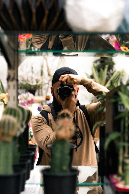 Man Taking Picture behind Cactus