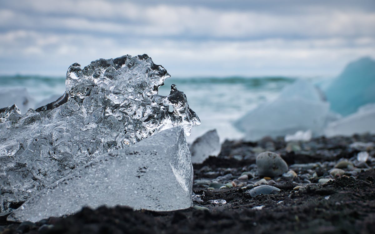 Ice and Pebbles on Ground on Shore