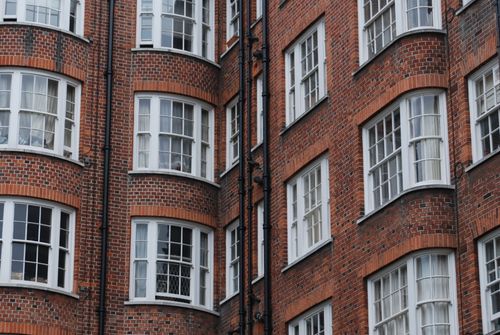 Free Red brick residential building with traditional windows in London, highlighting classic urban architecture. Stock Photo