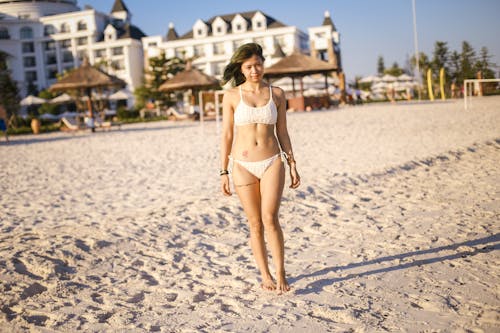 Woman in White Bikini Standing on White Sand
