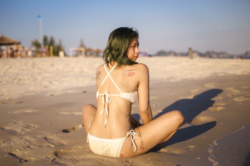 Woman Sitting on Sand at the Beach