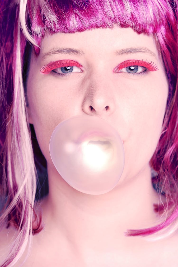 Woman With Pink Hair Making Gum Balloons