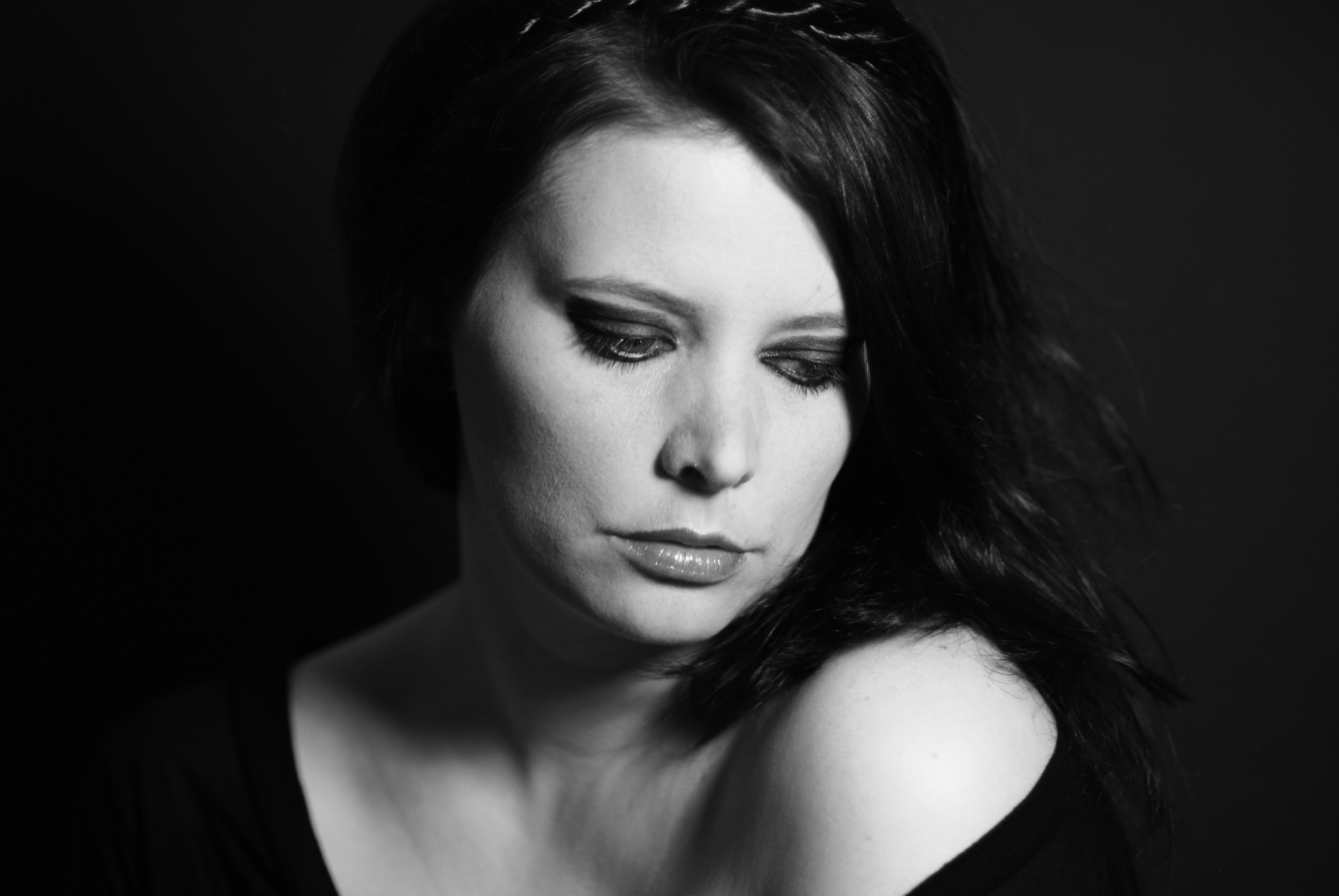 Graceful black and white portrait of a woman with thoughtful expression, soft lighting.