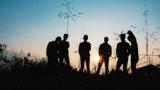 Silhouette Group of People Standing on Grass Field