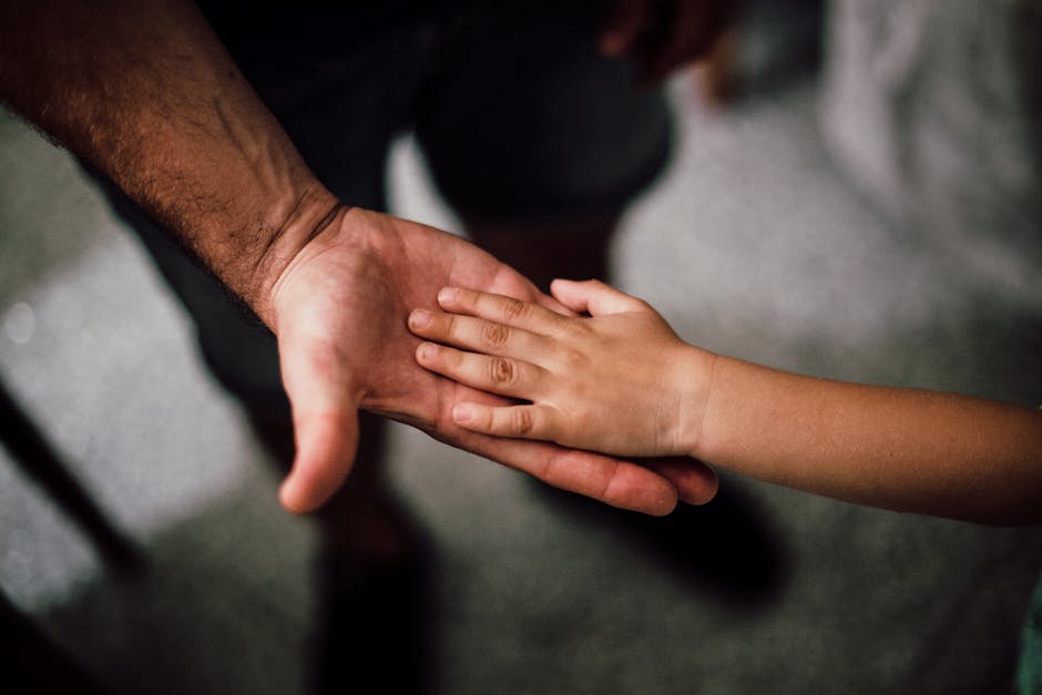 Selective Focus Photography of Child's Hand on Person's Palm