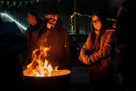 Man and Woman Standing Near Fire Pit during Night Time