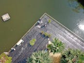 在一个阳光明媚的日子里，航拍照片捕捉了印度尼西亚绿树成荫的湖边长廊上的人们