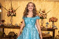 Woman in Blue Floral Dress Standing Near Brown Wooden Table