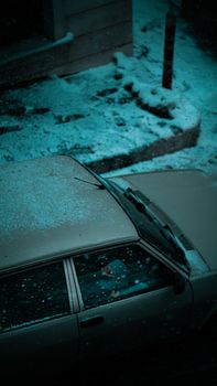 High-angle view of a parked vintage car covered in snow on an Istanbul street at night.