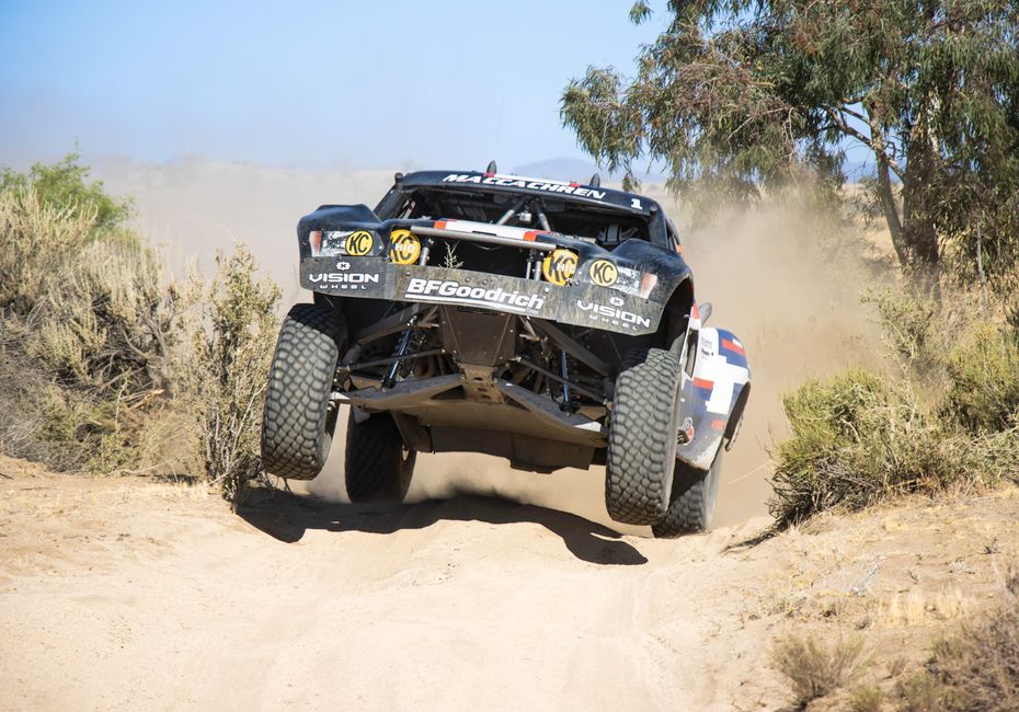 All-terrain vehicle racing through rugged desert terrain in Mexico, capturing intense action and dust clouds.