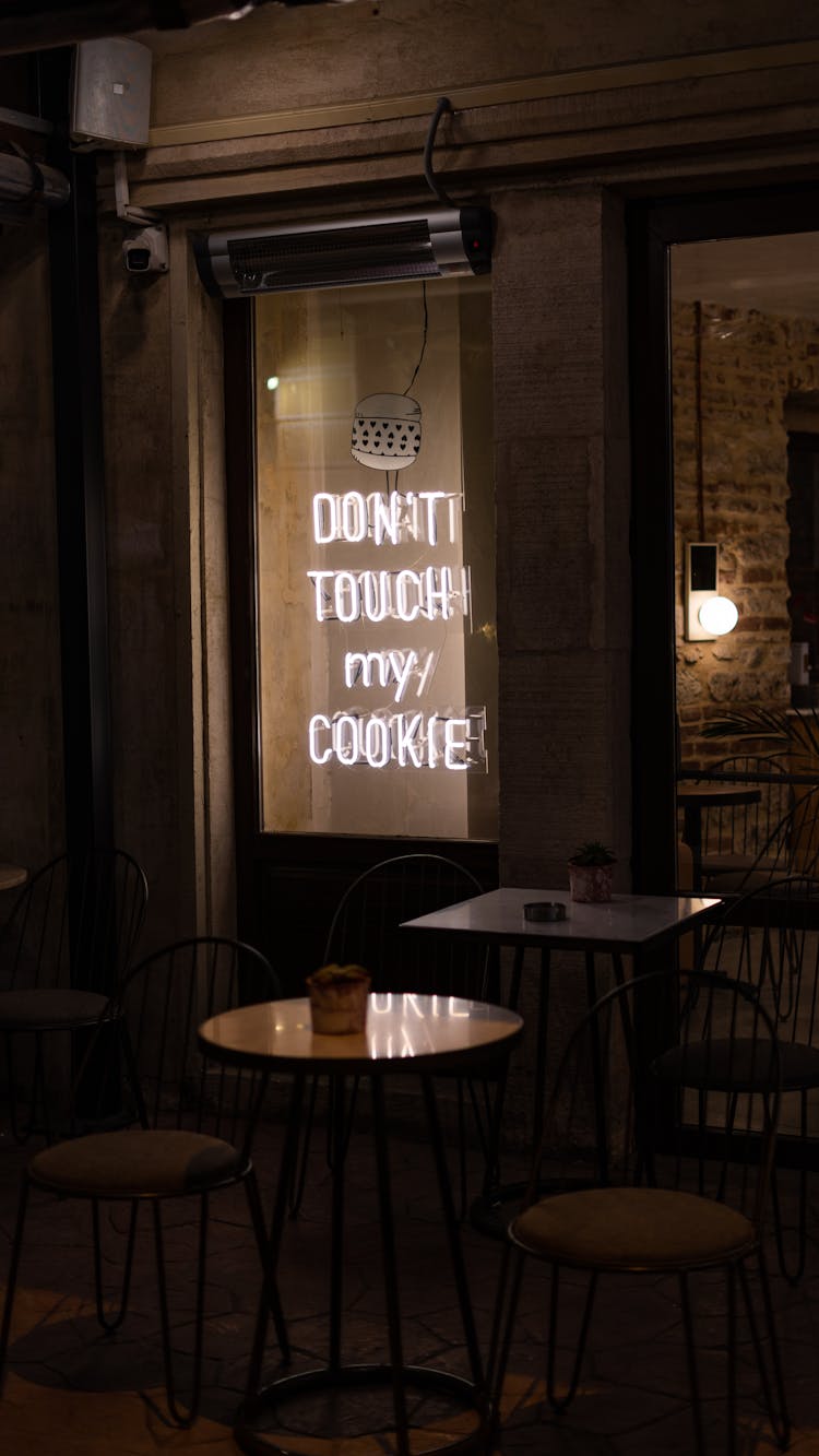 Illuminated Neon Signage Near Bar Tables