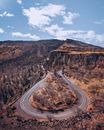 Gray Asphalt Road Between Brown Mountains Under Blue Sky