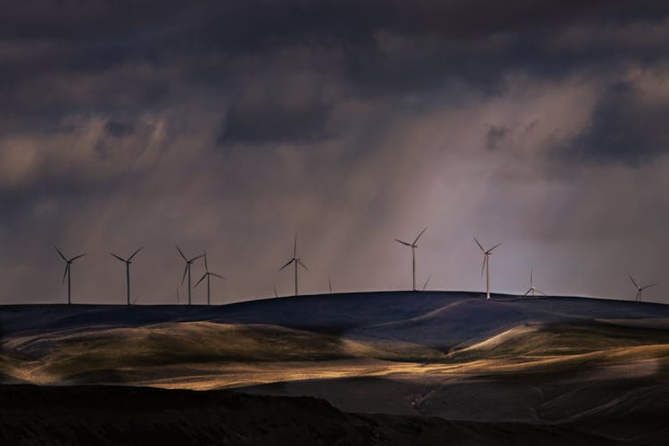 Clouds And Rain Over A Wind Turbine Farm On The Hills