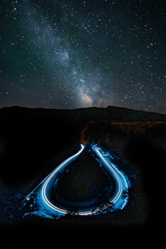 Long exposure of a winding road illuminated under a star-filled sky in Oregon.