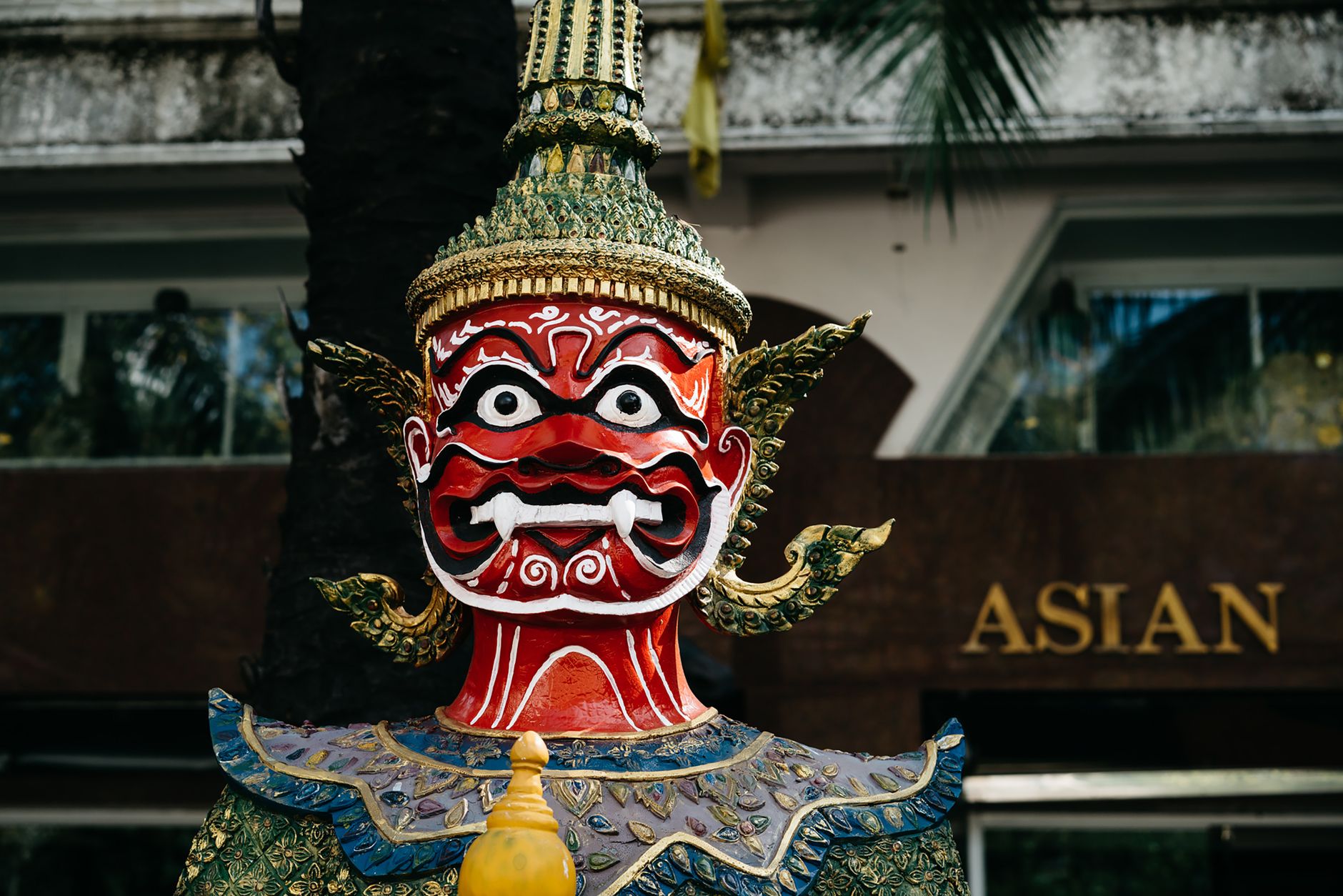 Close-up of a vibrant and ornate traditional Asian sculpture featuring intricate patterns and vivid colors.