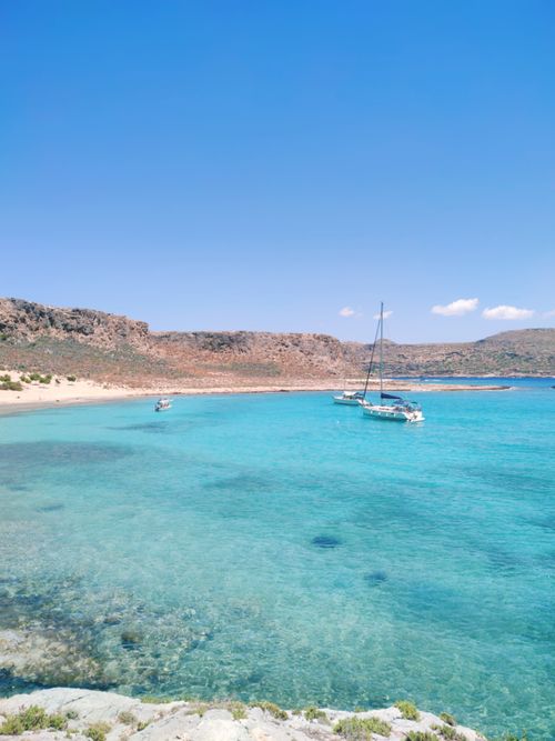 Free Serene view of turquoise waters and sailboats at Gramvousa beach, Greece. Stock Photo