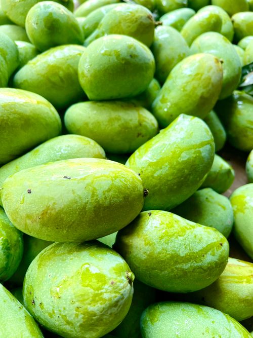 Free Vibrant green mangoes stacked closely, showcasing their natural freshness from a Goa market. Stock Photo