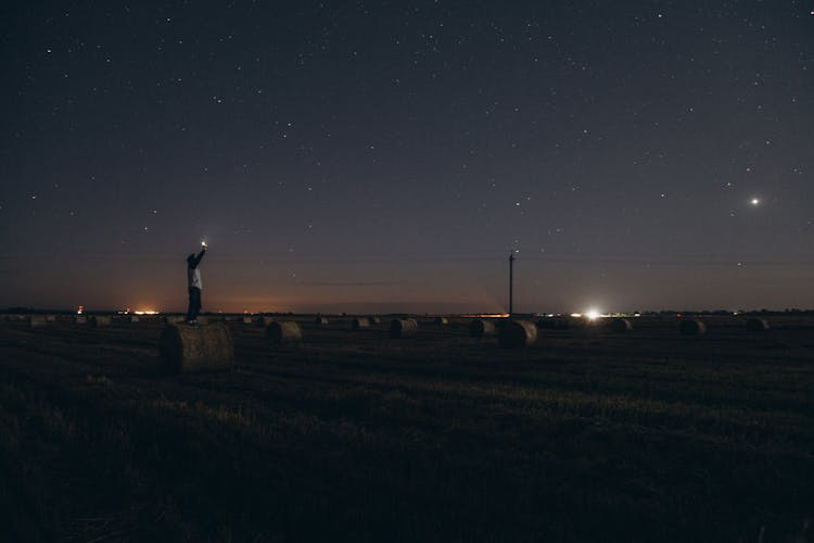 Man Reaching Stars On Field