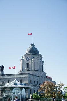 Quebec City landmark with Canadian flags and clear sky, capturing local architecture.