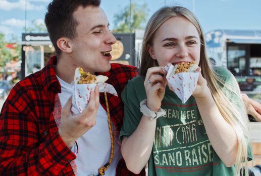 Happy couple enjoying street food together in Wrocław, Poland outdoors.