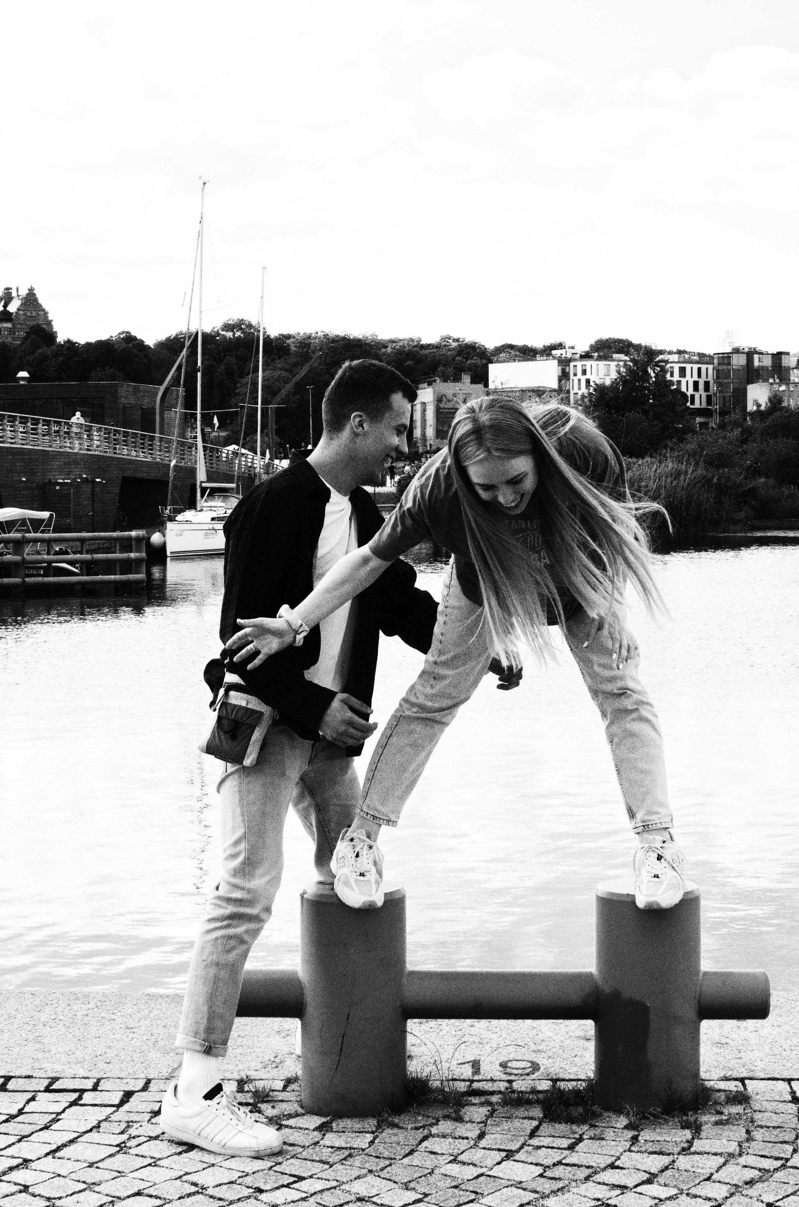 Young couple enjoying playful moments by the lake in Łódź, Poland.