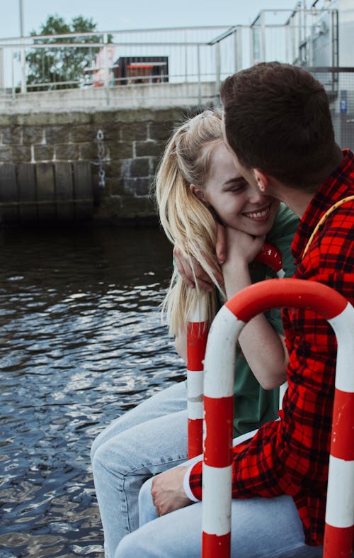 Man in Red Plaid Shirt Kissing a Woman