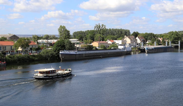 A Motorboat Cruising On River Near Buildings