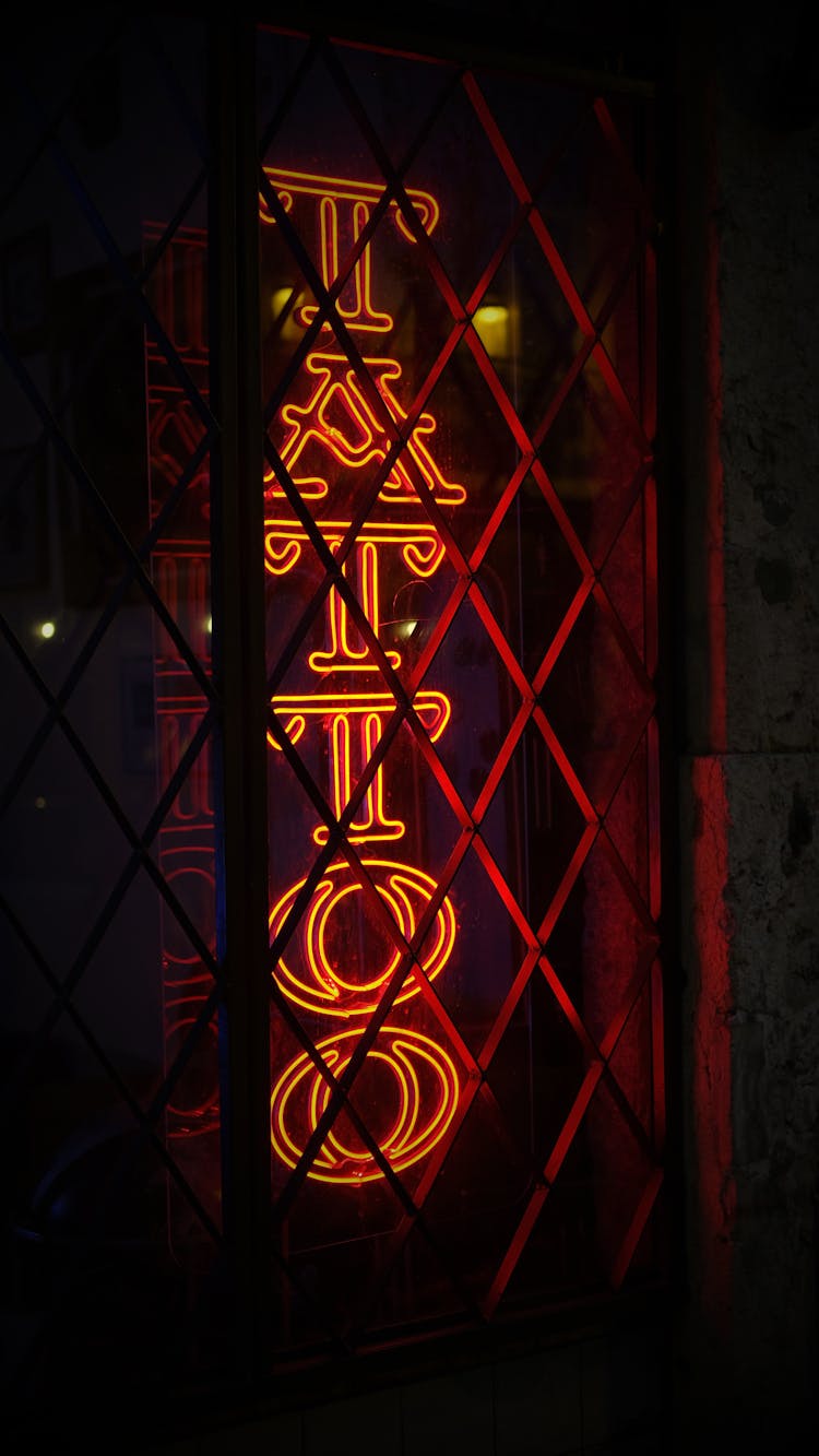 A Tattoo Neon Sign Illuminated At Night